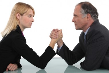 Businessman and woman arm wrestling